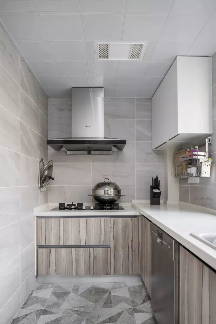 厨房墙面铺设了浅灰色的墙砖,地面则是铺着有3d素描质感的地砖