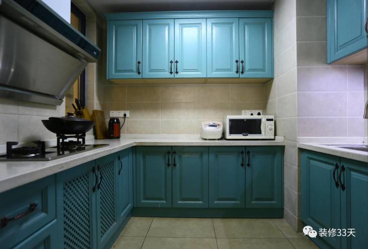 厨房用孔雀蓝的模压橱柜配黑色复古拉手,呈现质感