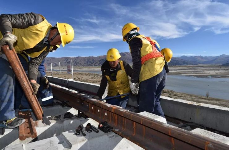 中铁十一局的工人在川藏铁路拉林段昌果特大桥进行铺轨作业(10月16日